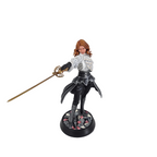 A painted fantasy figurine of a female warrior holding a sword, standing on a circular base against a white fabric backdrop.